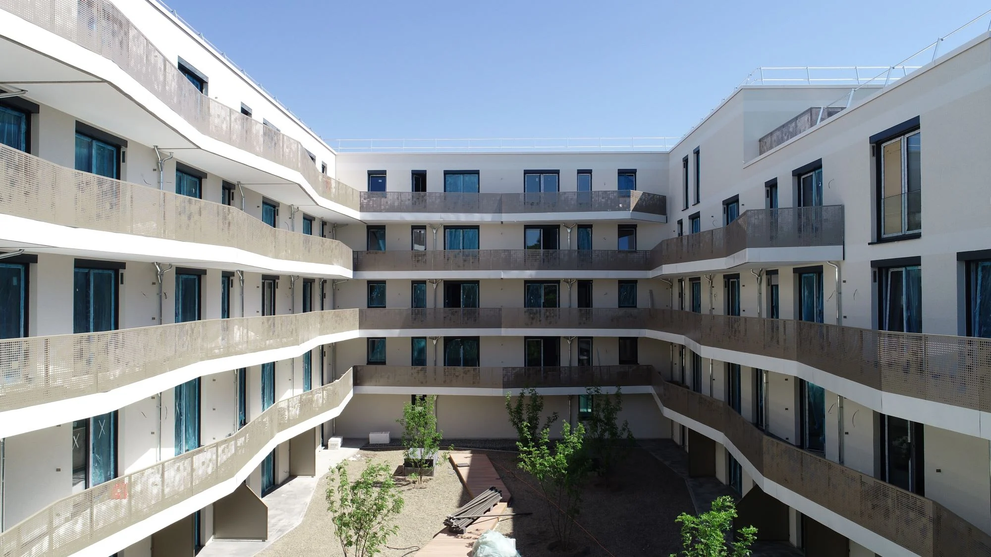 Wohnprojekt Roomy Wiesbaden – Innenhof des fertiggestellten Neubaus mit geschwungenen Balkonen